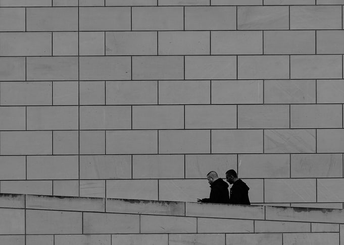 Two Men by Brick Wall