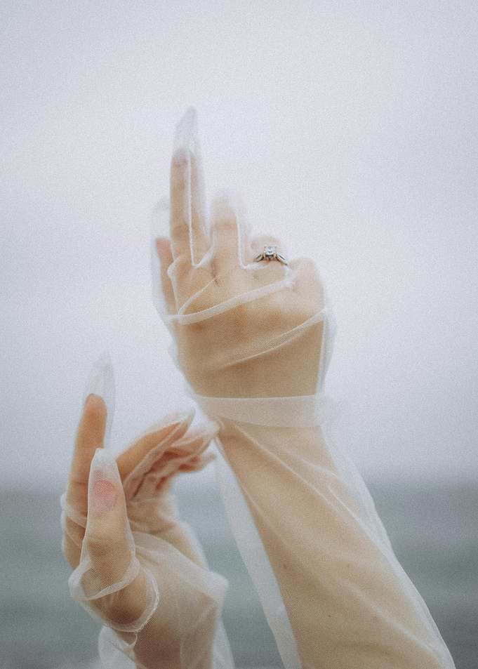 Hands in sheer gloves with ring