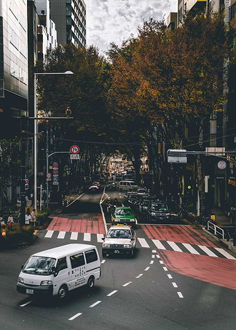Japanese city street with cars and trees