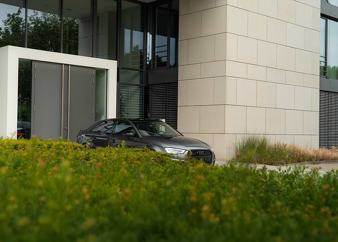Gray Audi Sedan near Modern Building