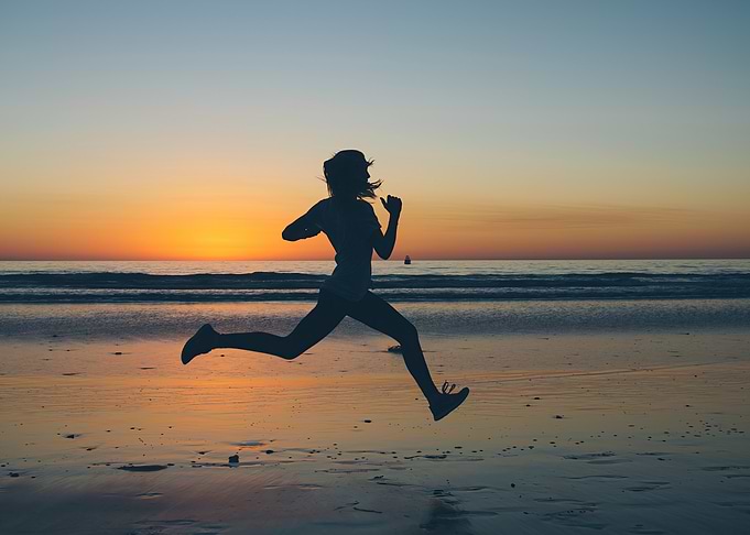 Silhouette of Woman Running on Beach