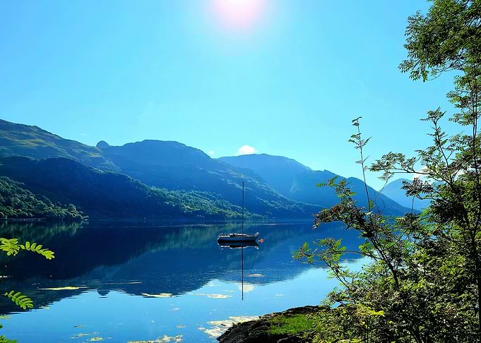 Sailboat on a serene lake landscape, Scotland