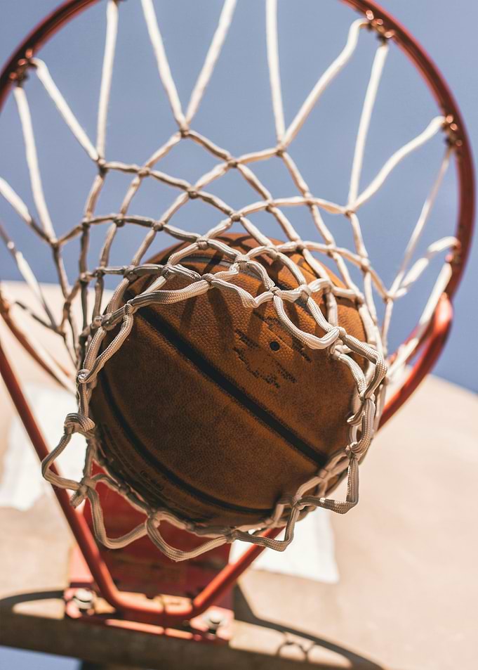 Basketball in Net Against Blue Sky