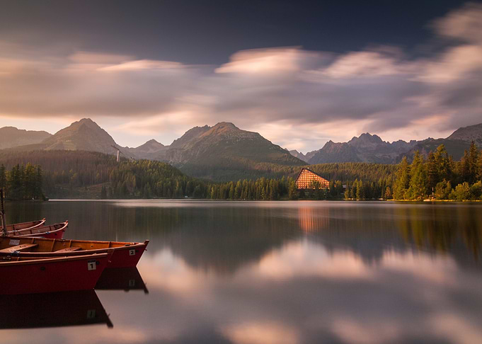 mountain lake with boats and reflections