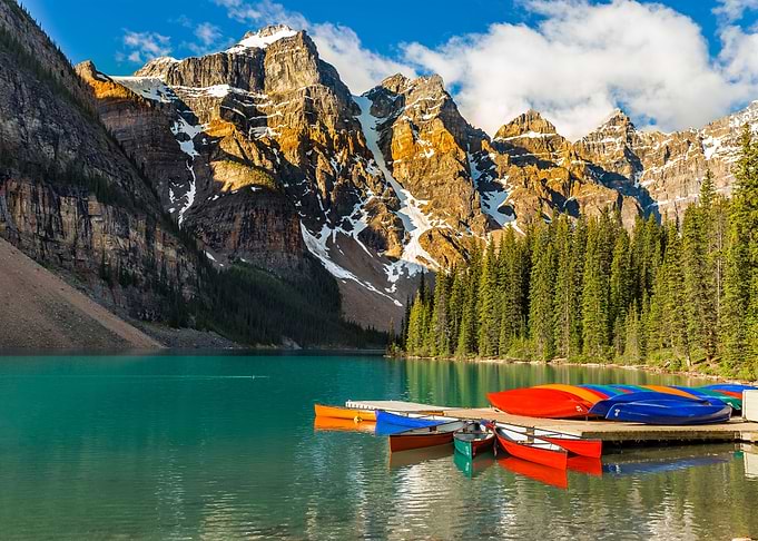 moraine lake with canoes and mountains