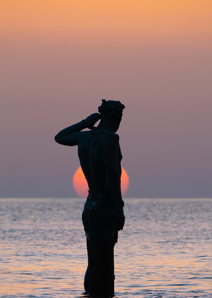 Statue Silhouette at Sunset by the Sea