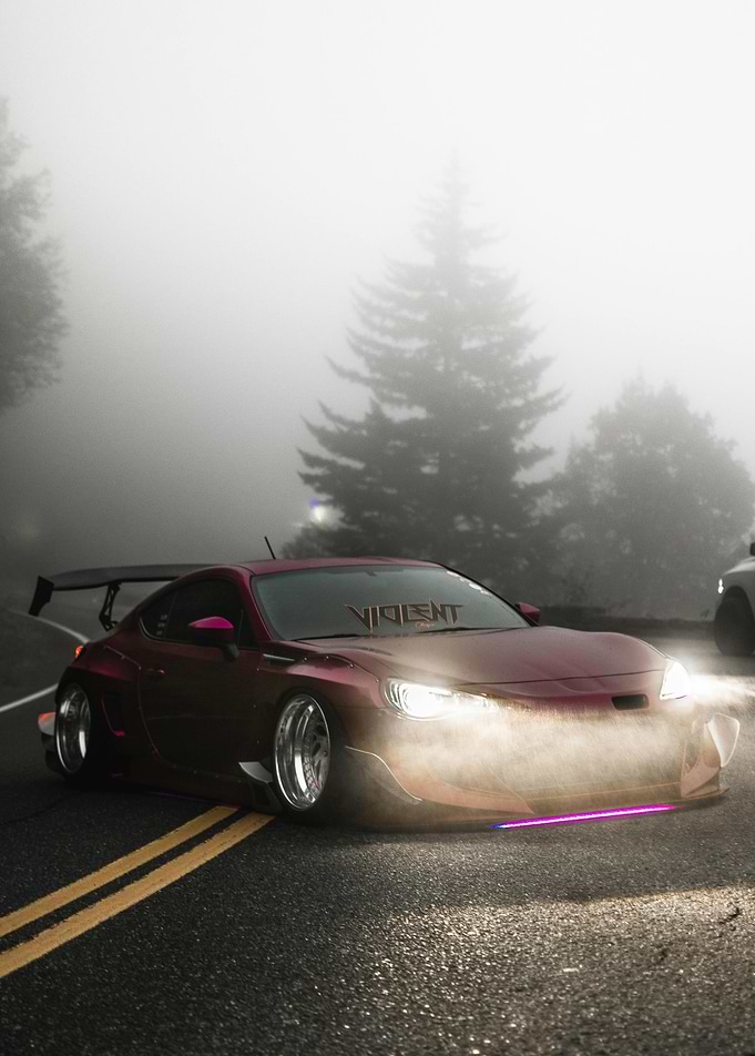 Maroon Car on Foggy Road