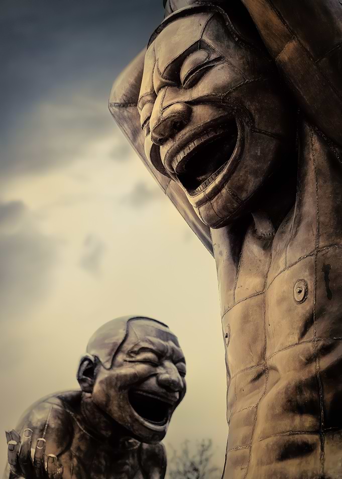 Laughing Statues Under Cloudy Sky