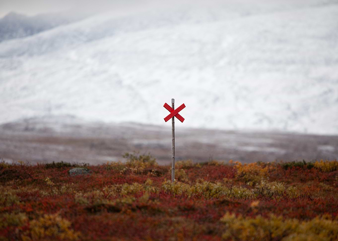 Red trail marker and autumn colors in a snowy landscape