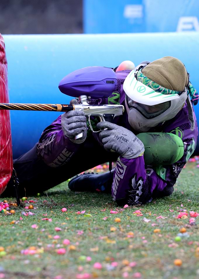 Paintball Player Aiming Gun on Field