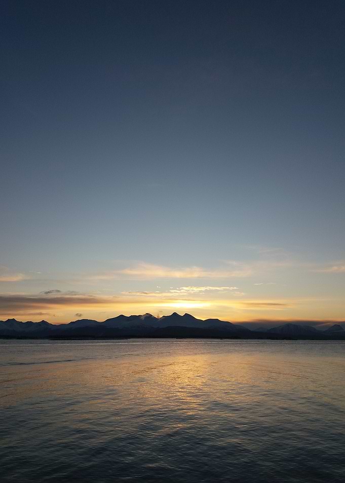 Sunset over water with mountain backdrop