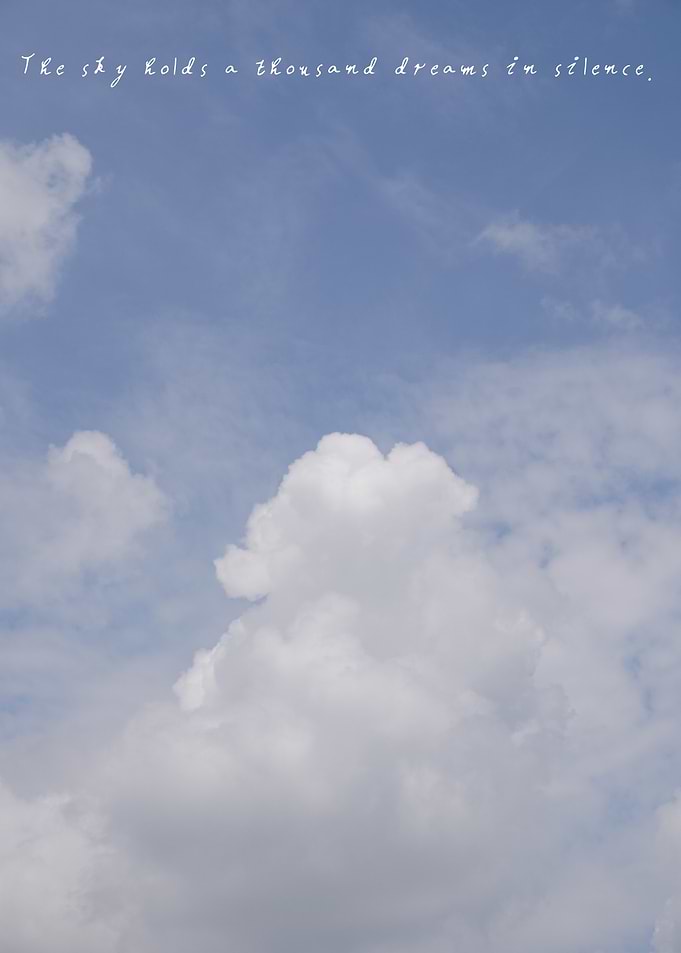 The vast expanse of sky holds delicate clouds, a reminder of the dreams it keeps unspoken.
