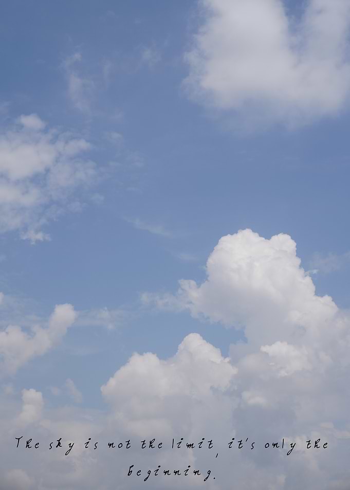Bright blue sky with soft white clouds drifting across.
