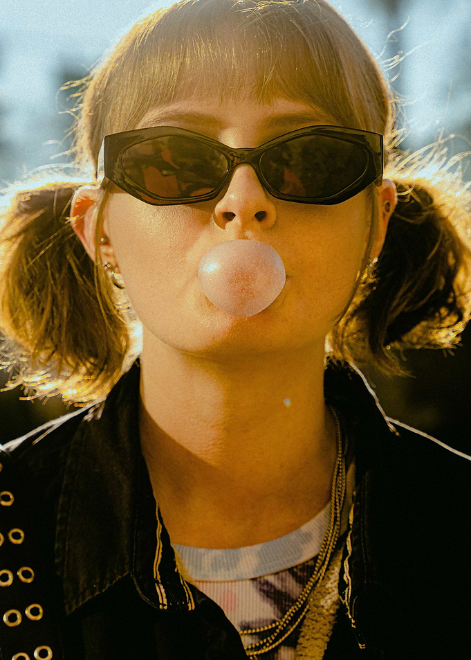 Girl blowing bubblegum with sunglasses
