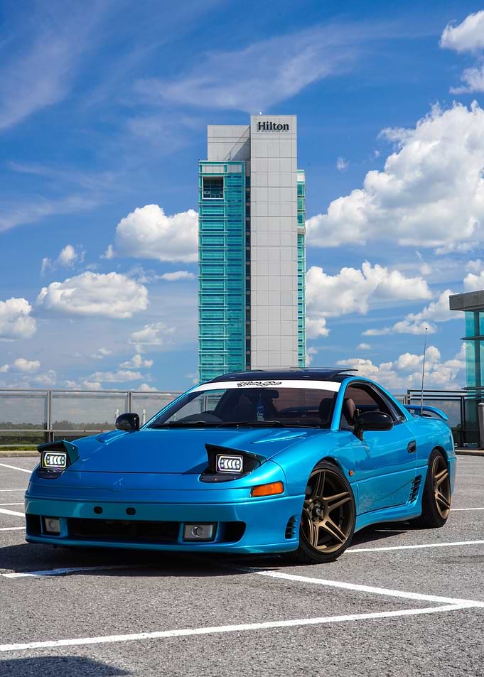Blue Mitsubishi 3000GT with Hilton backdrop