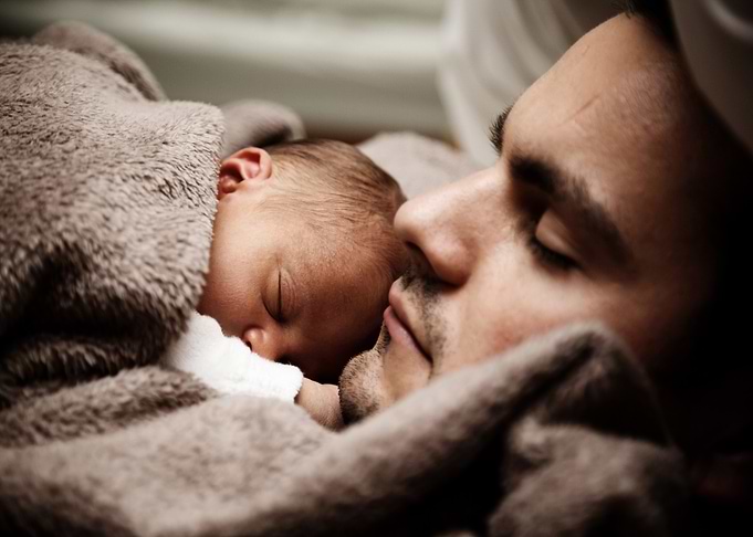 Father and baby sleeping peacefully together