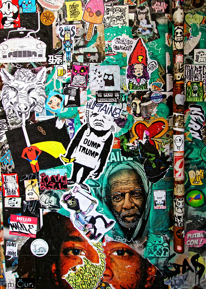 Sticker-covered wall with diverse imagery