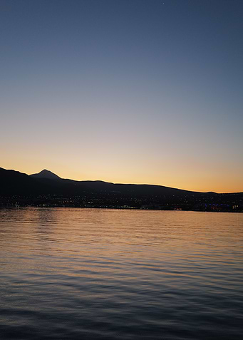 Sunset over water with mountain silhouette