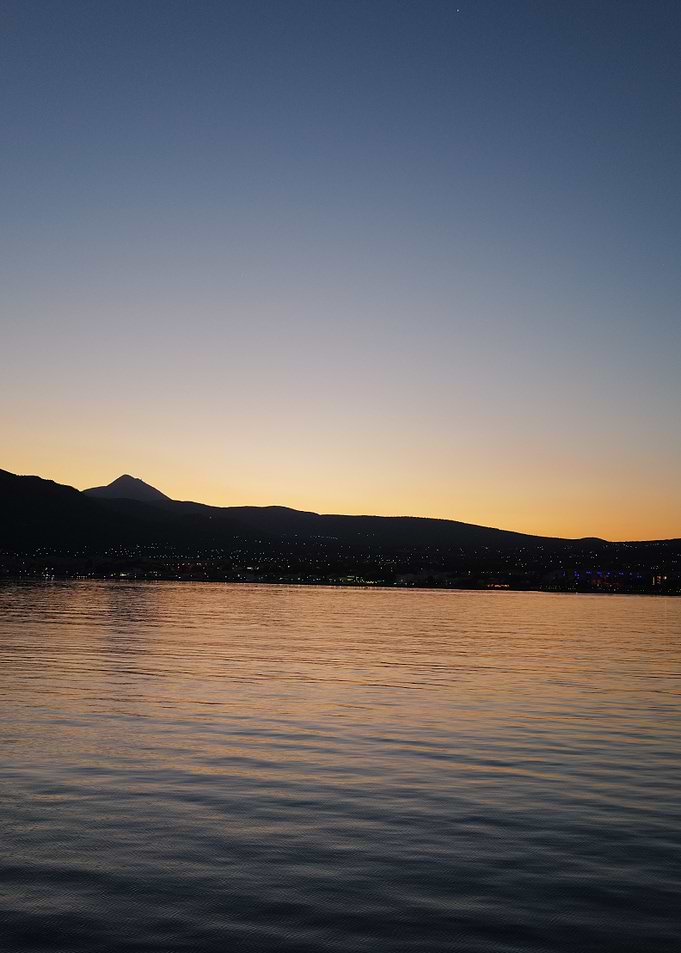Sunset over water with mountain silhouette