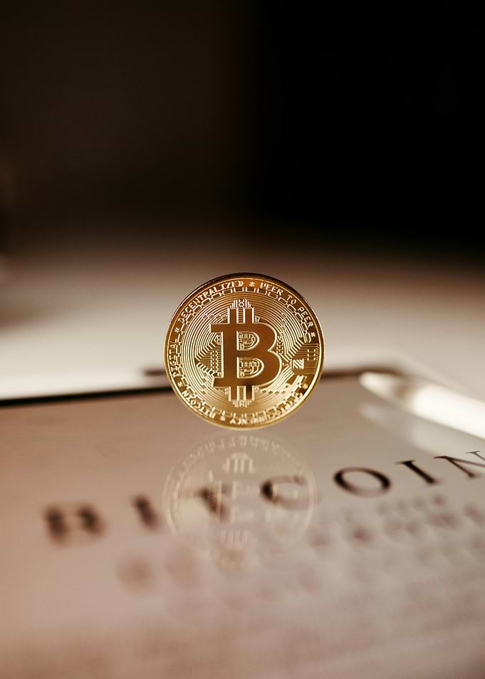 Golden Bitcoin Coin on Reflective Surface