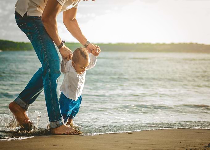 Father and child walking on beach