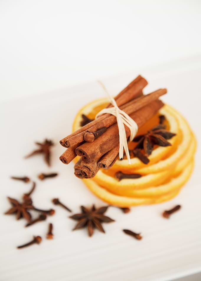 Cinnamon sticks, orange slices, and spices