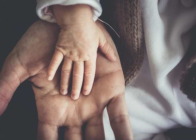 Baby's hand on adult's palm