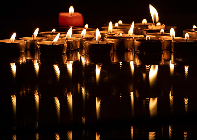 Candles with reflections on dark surface