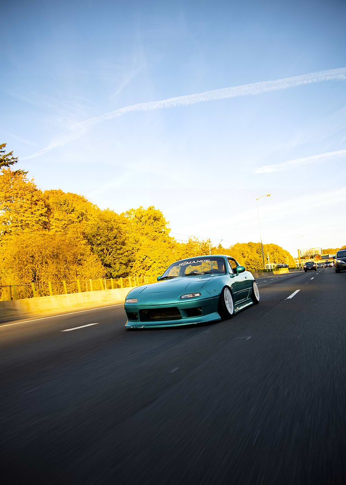 Teal Mazda Miata on Highway