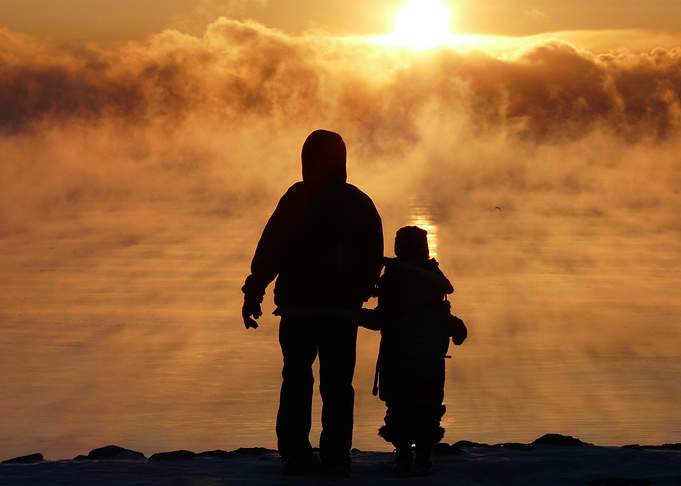 Silhouette of Father and Child at Sunrise