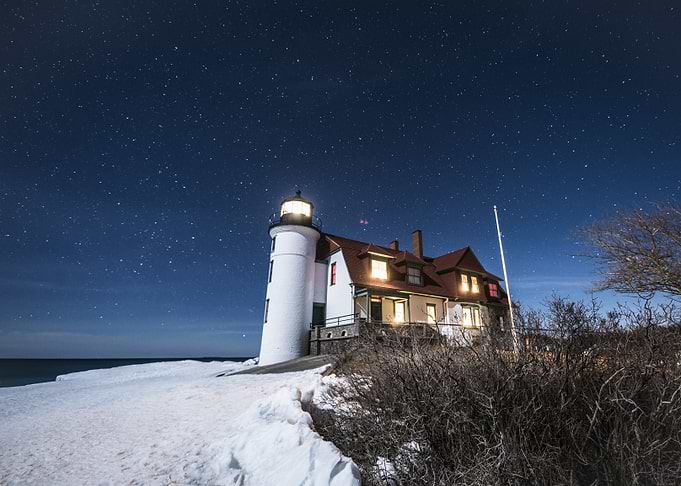 Lighthouse under starry night sky