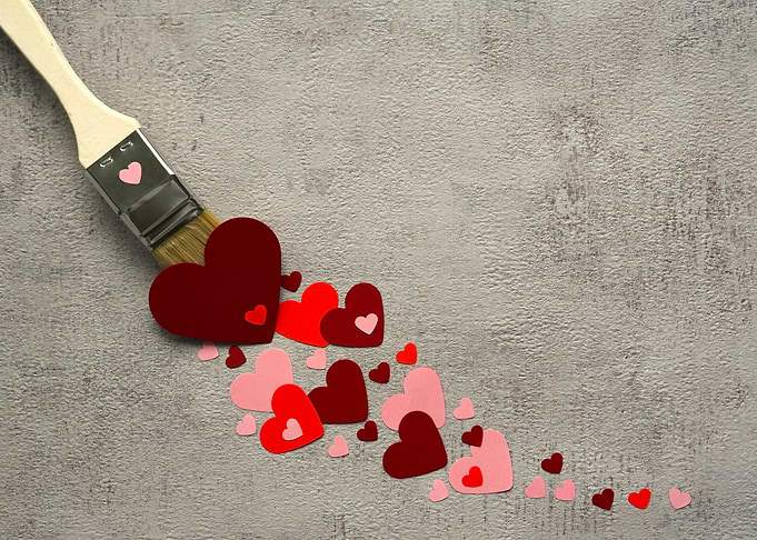 Paintbrush with hearts on gray background