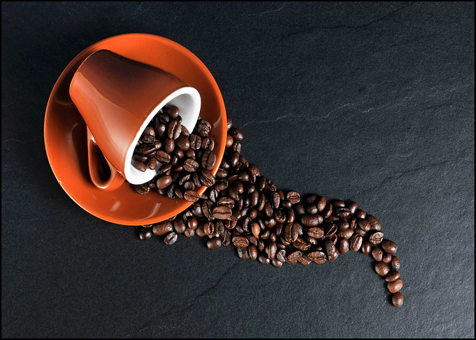 Coffee Beans Spill from Orange Cup
