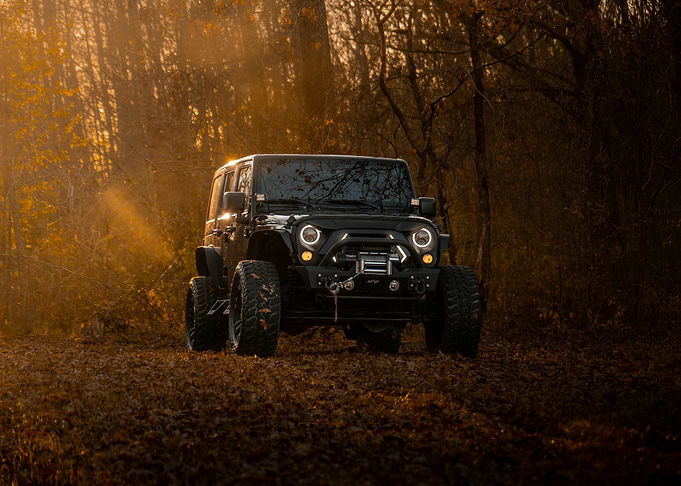 Black Jeep Wrangler in Autumn Forest