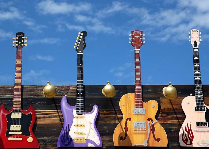 Colorful Guitars on Wooden Wall