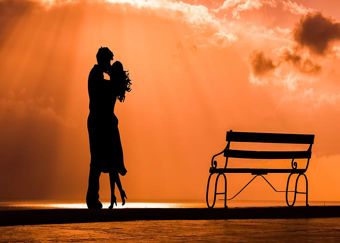 Silhouette of a couple kissing at sunset