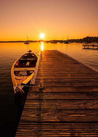 Sunset over lake with boat and pier