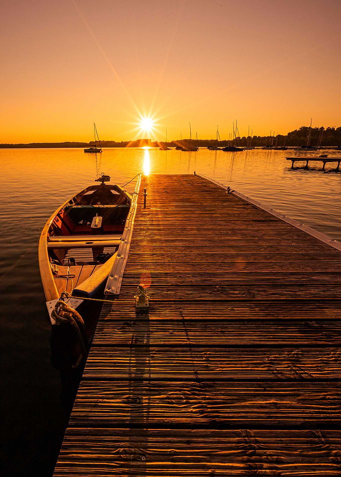 Sunset over lake with boat and pier