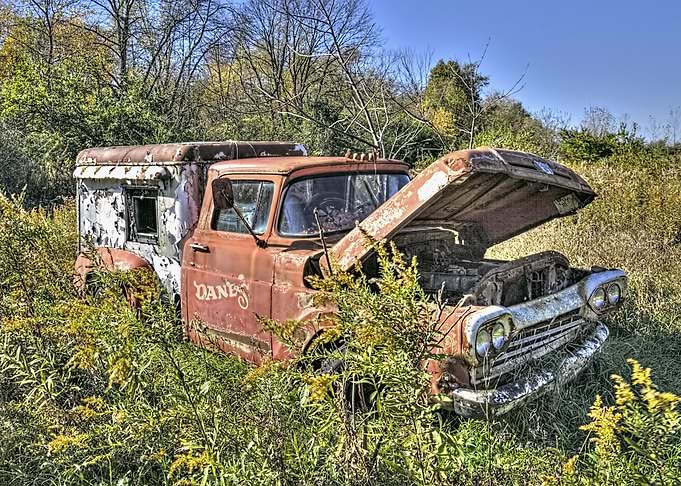 Abandoned Rusty Truck in Overgrown Field