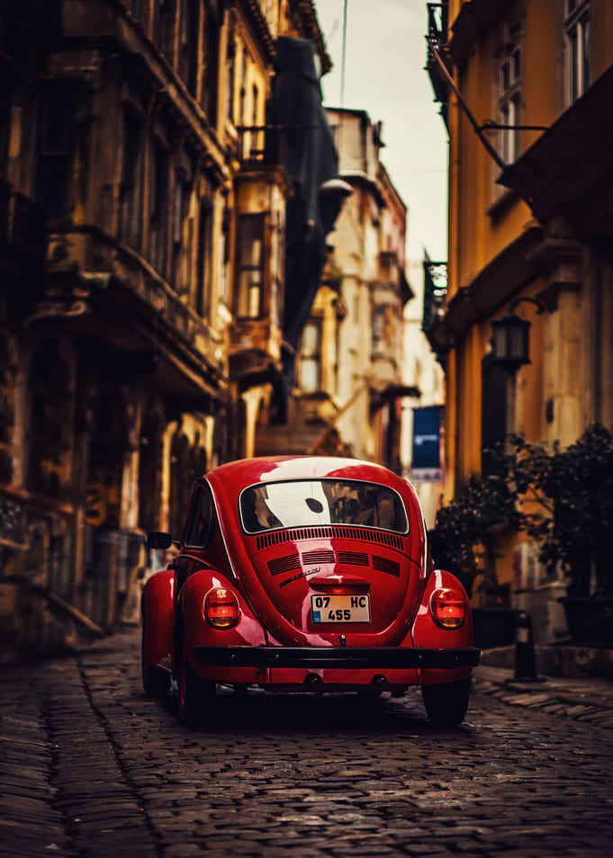 Red Volkswagen Beetle on Cobblestone Street