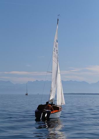 Sailboat on calm water, blue sky