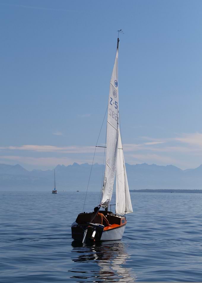 Sailboat on calm water, blue sky