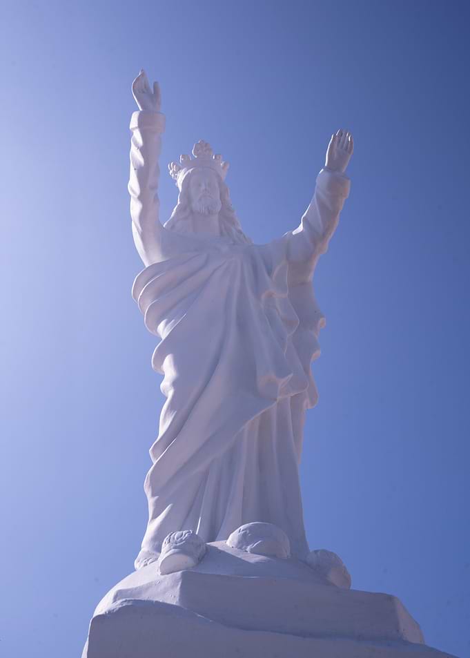 White Jesus Statue Against Blue Sky