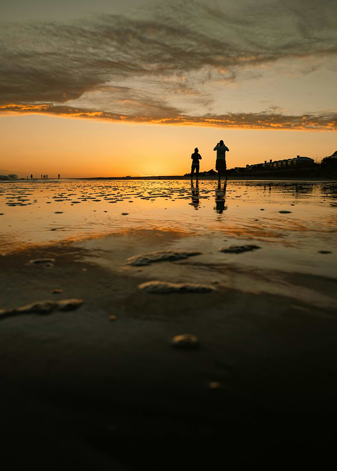 Sunset beach with silhouettes of people