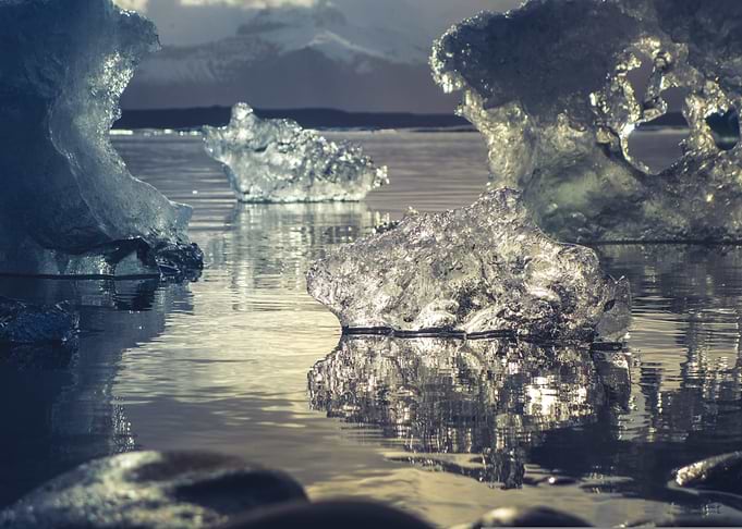 Icebergs in Water with Mountain Backdrop