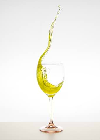 Yellow Liquid Splash in Wine Glass
