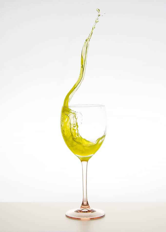 Yellow Liquid Splash in Wine Glass