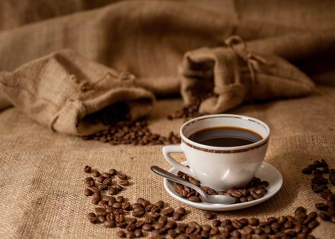 Coffee cup with beans and burlap