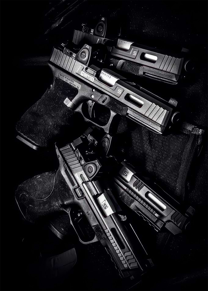 Monochrome Pistols Stacked on Dark Fabric