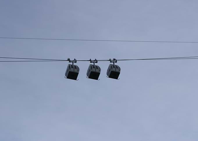 Three Cable Cars Against a Pale Sky
